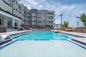 Sparkling resort style pool with lounge chairs to soak up the sun
